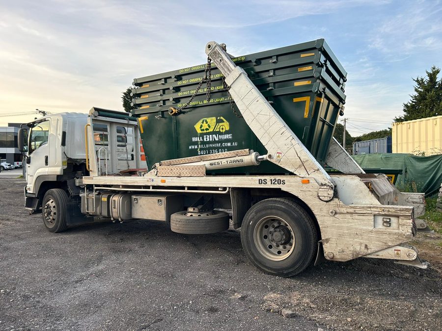 Bill Bin Hire truck loaded with a green skip bin