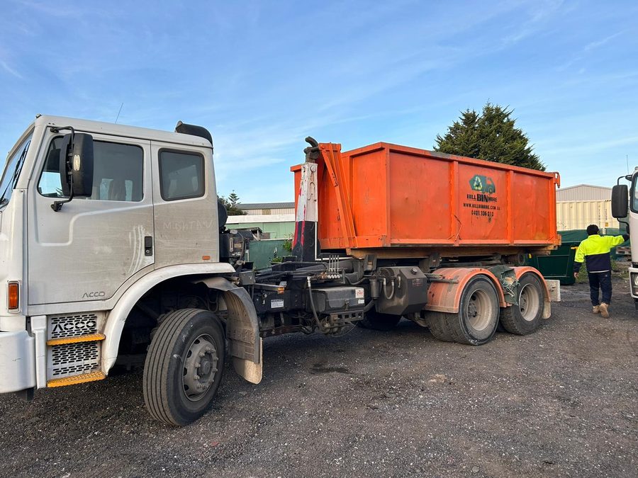 Bill Bin Hire truck delivering an orange skip bin