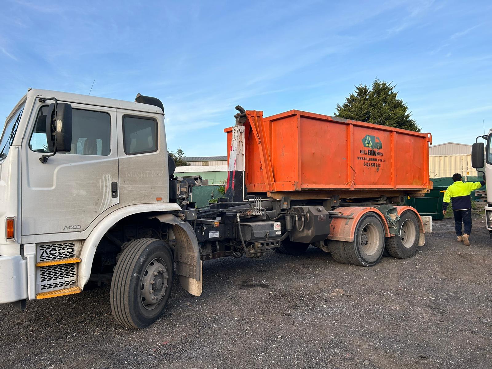 Bill Bin Hire truck delivering an orange skip bin